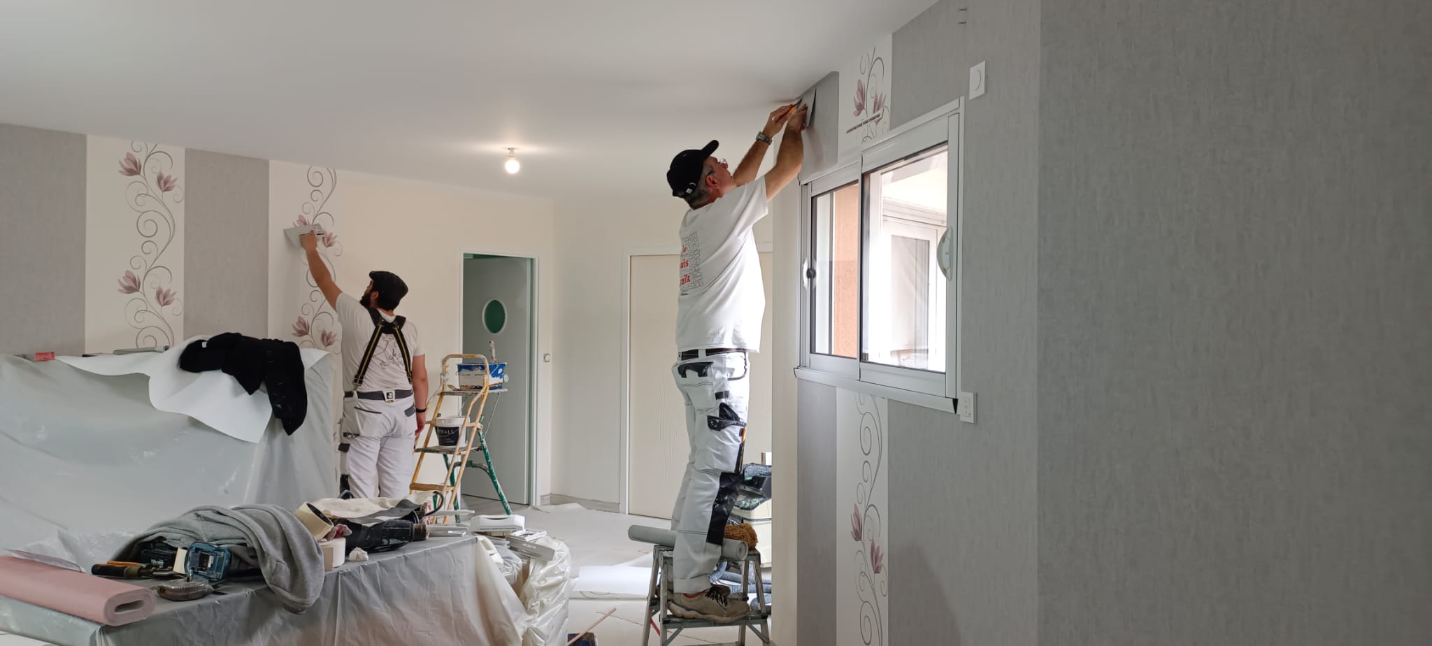 L'équipe Alzaix au travail : pose de papier peint et finitions sur un chantier